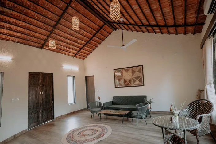 Living room of a woodland cottage with a sofa and wooden ceiling
