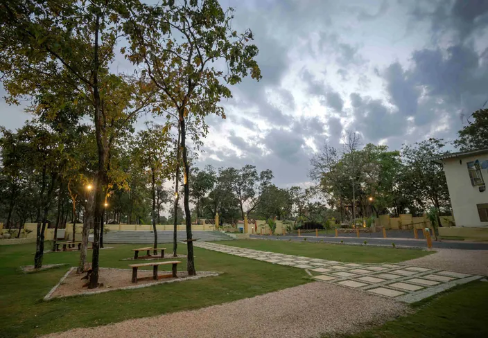 Lawn with a stone path at Palash Jungle Resort