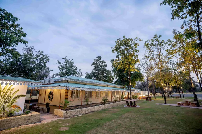 Cottage lit up at dusk at Palash Jungle Resort