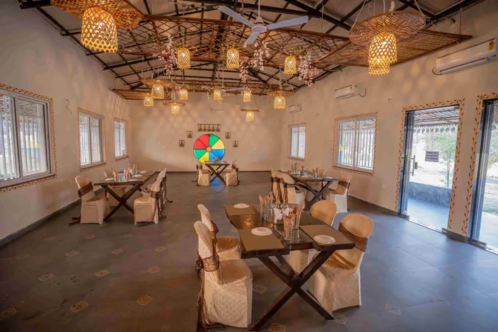 Themed dining hall with lanterns and wooden tables at Palash Jungle Resort