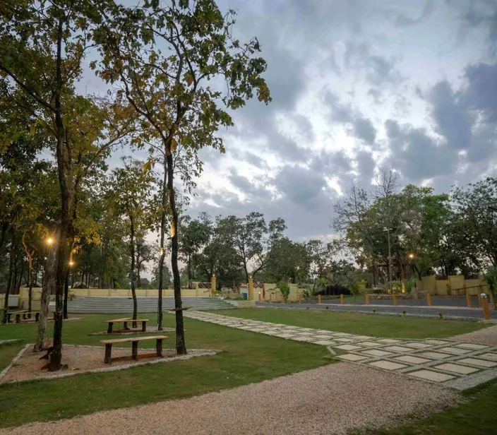 Lawn with a stone path at Palash Jungle Resort