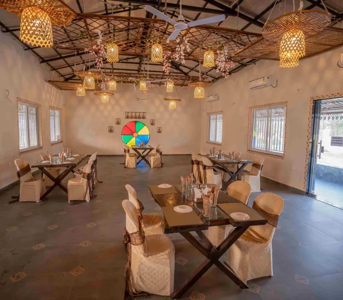 Themed dining hall with lanterns and wooden tables at Palash Jungle Resort