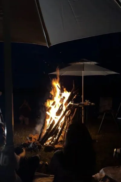 Bonfire burning at night under an umbrella